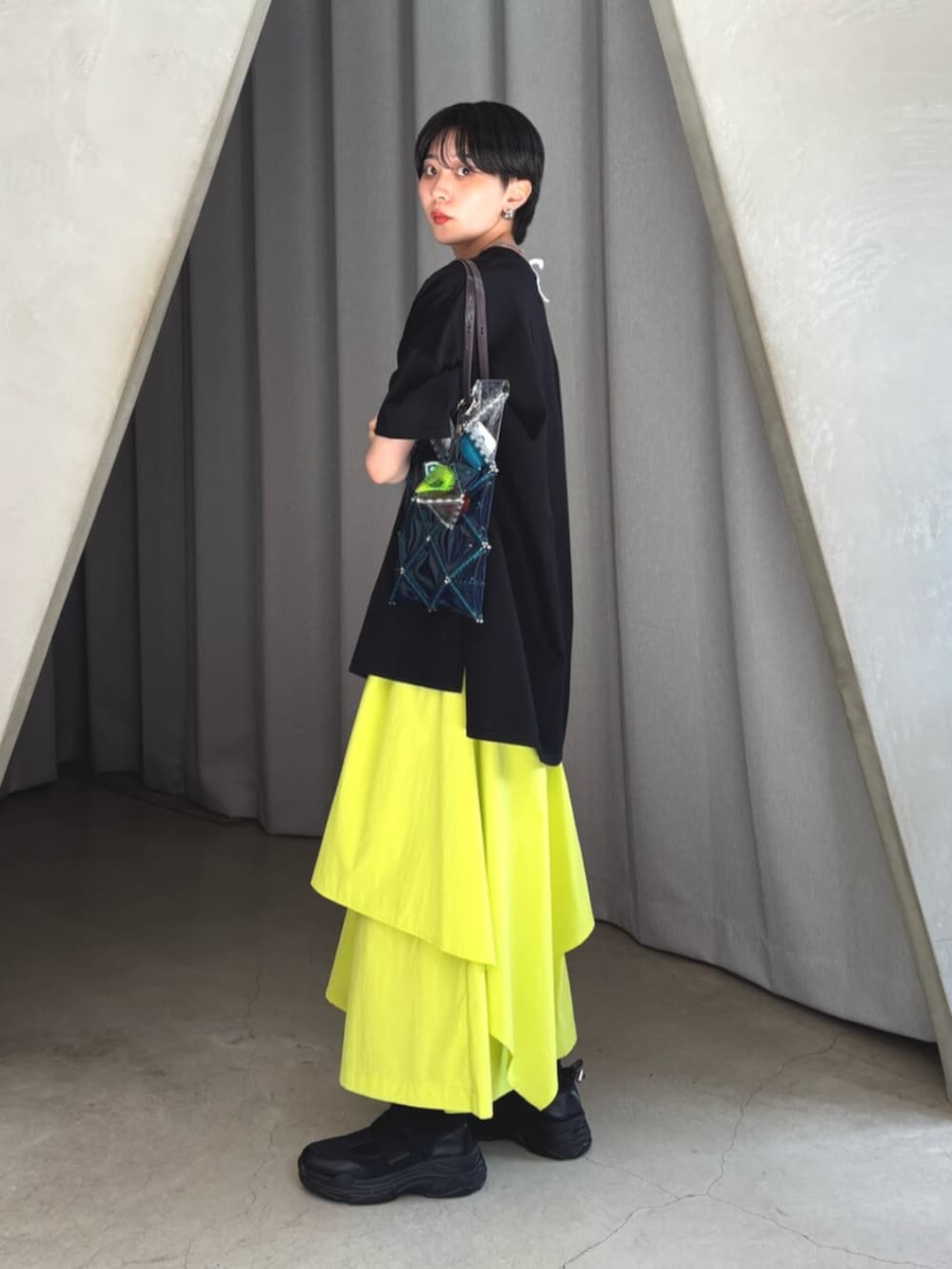 ブラック系のTシャツ/カットソー、イエロー系のその他パンツ、ブラック系のスニーカーを着用したレディースの夏コーディネートの2枚目の写真