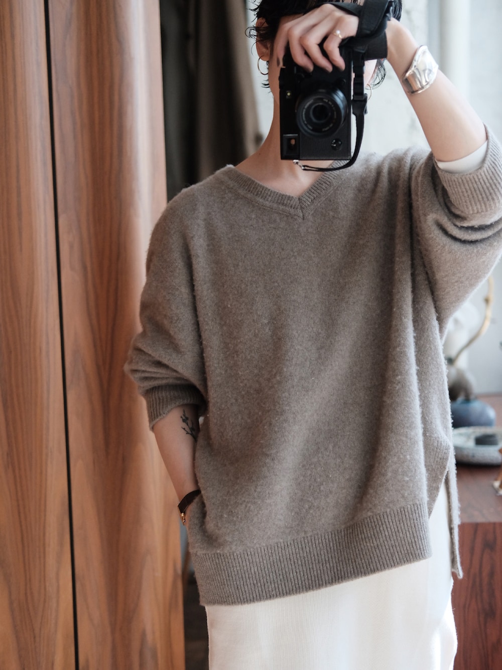 ホワイト系のスカート、ベージュ系のニット/セーター、ブラック系のドレスシューズを着用したレディースの春コーディネートの2枚目の写真