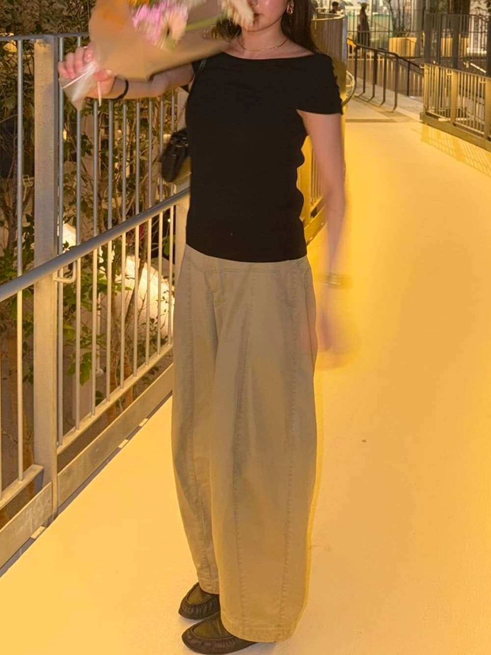 ベージュ系のカーゴパンツ、ブラック系のニット/セーター、ブラック系のローファーを着用したレディースの夏コーディネートの2枚目の写真
