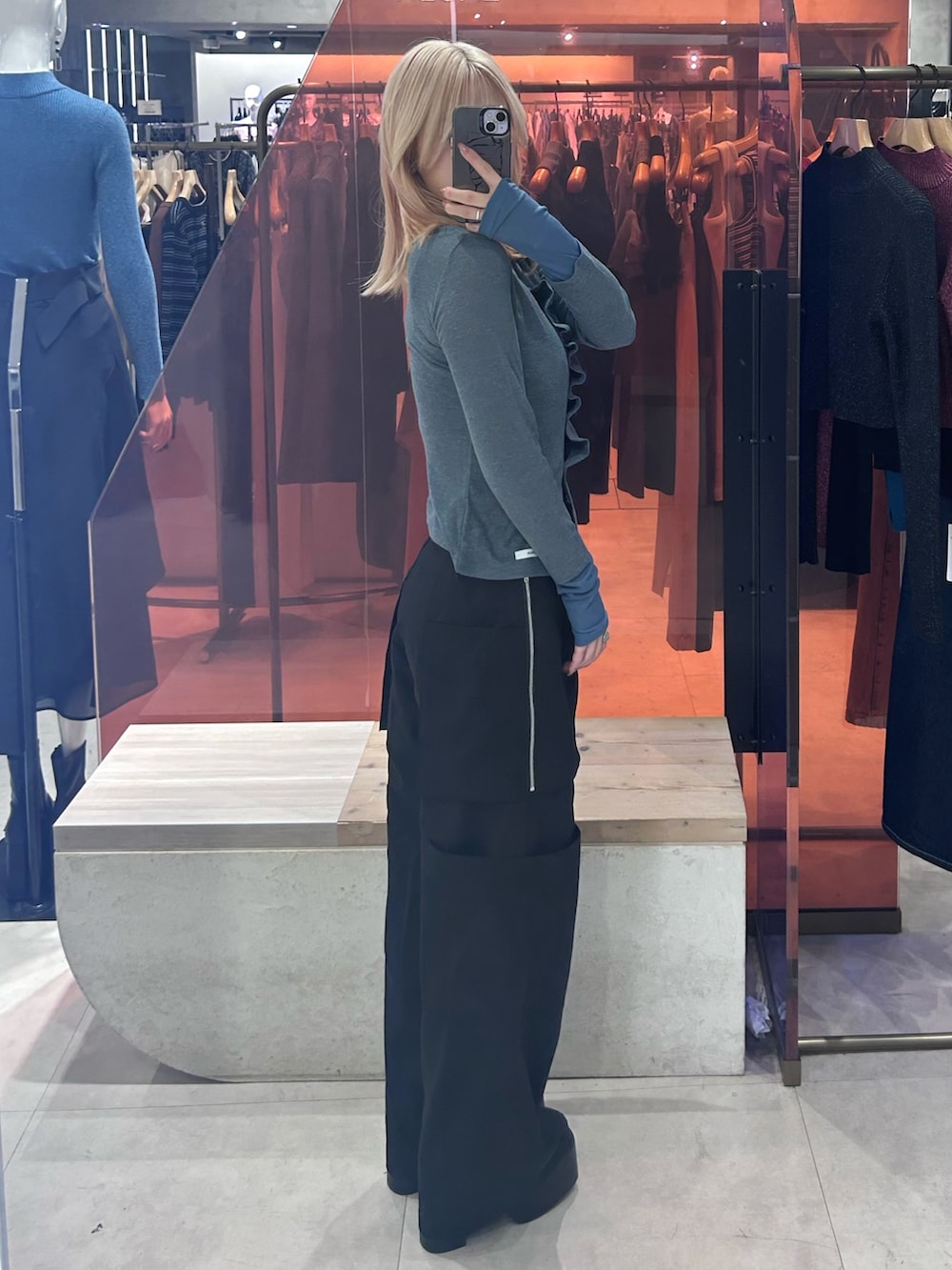 ブラック系のカーゴパンツ、ブラック系のブーツ、ブルー系のカーディガン/ボレロを着用したレディースの春コーディネートの2枚目の写真