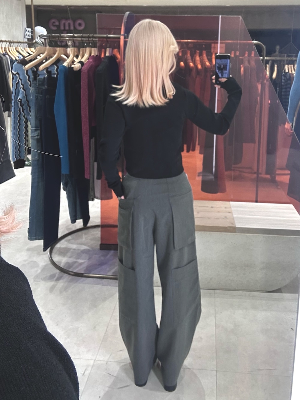 ブラック系のニット/セーター、グレー系のカーゴパンツ、ブラック系のブーツを着用したレディースの春コーディネートの3枚目の写真