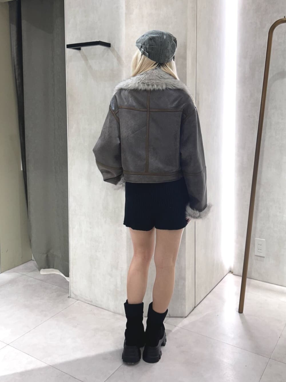 ブラウン系のムートンコート、ブラック系のその他パンツ、ブラック系のブーツを着用したレディースの夏コーディネートの3枚目の写真