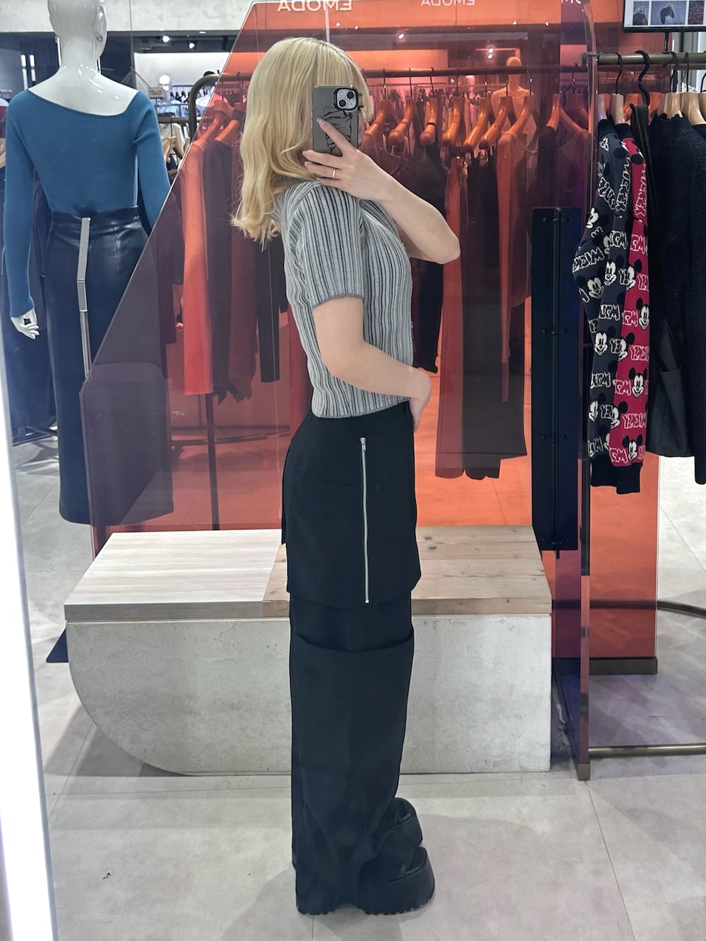 ブラック系のカーゴパンツ、ブラック系のブーツ、グレー系のニット/セーターを着用したレディースの春コーディネートの2枚目の写真