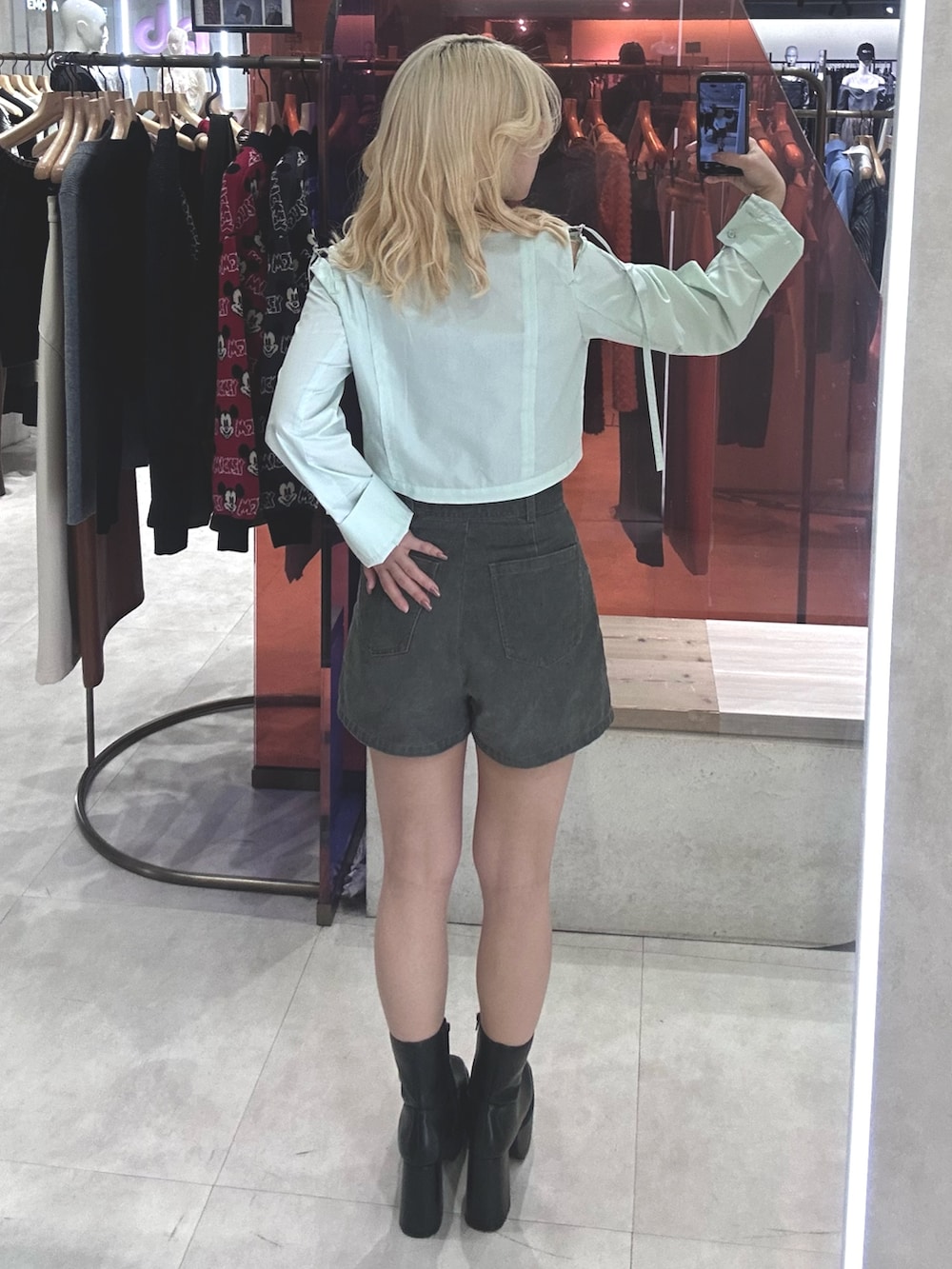 グレー系のその他パンツ、グリーン系のシャツ/ブラウス、ブラック系のブーツを着用したレディースの春コーディネートの3枚目の写真