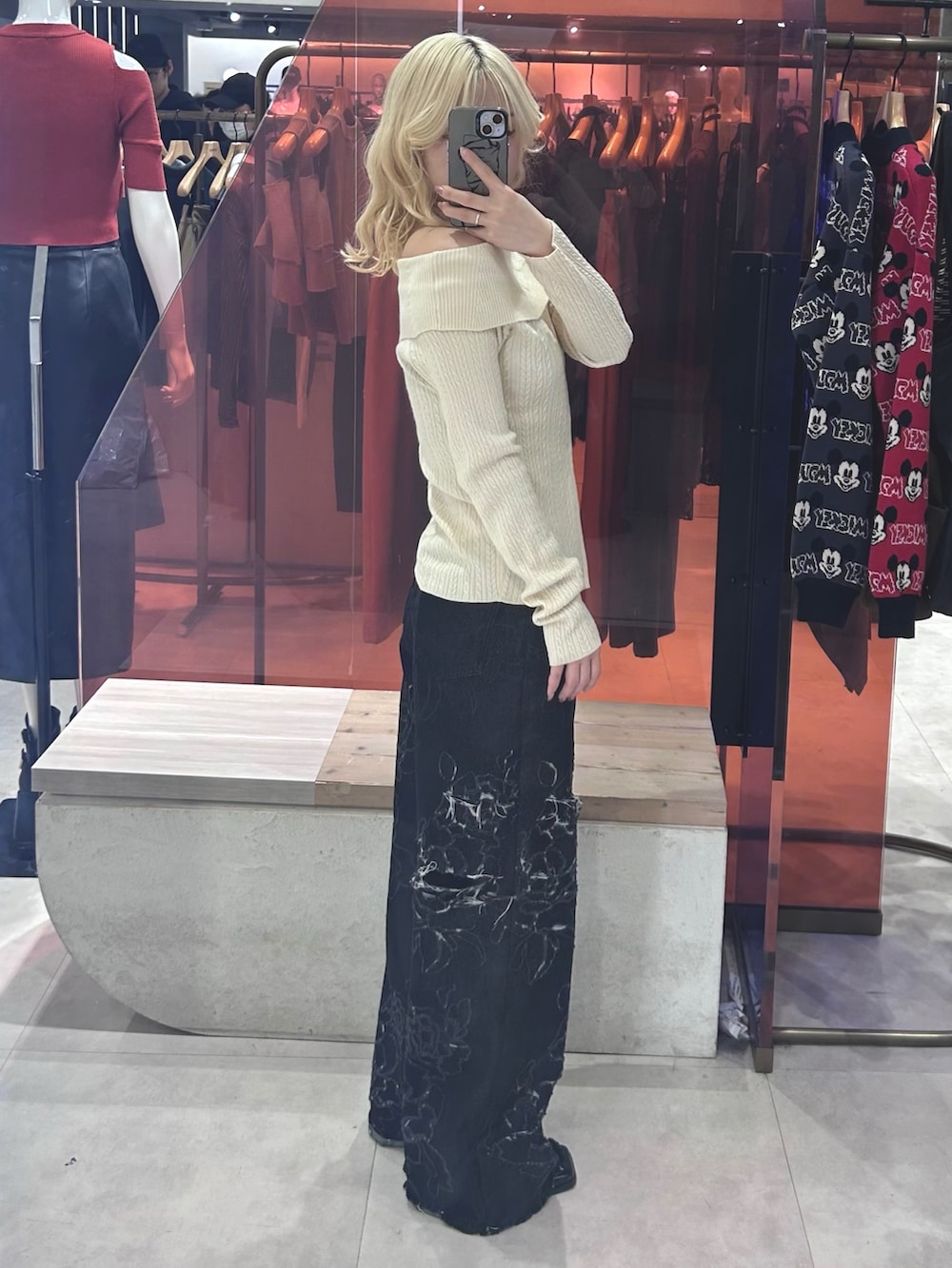 ホワイト系のニット/セーター、ブラック系のデニムパンツ、ブラック系のパンプスを着用したレディースの春コーディネートの2枚目の写真