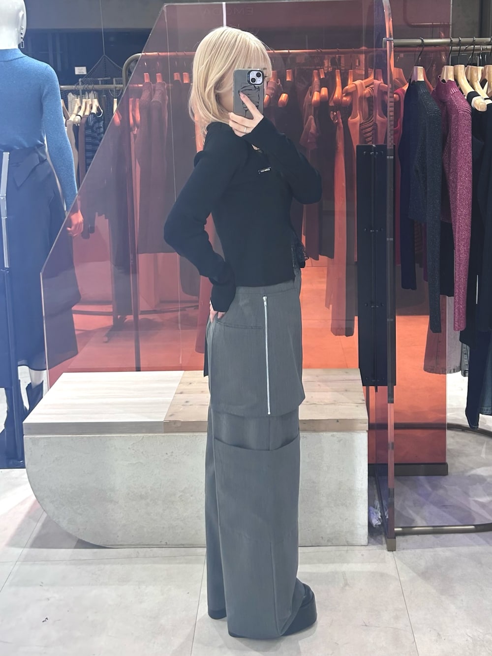 ブラック系のニット/セーター、グレー系のカーゴパンツ、ブラック系のブーツを着用したレディースの春コーディネートの2枚目の写真