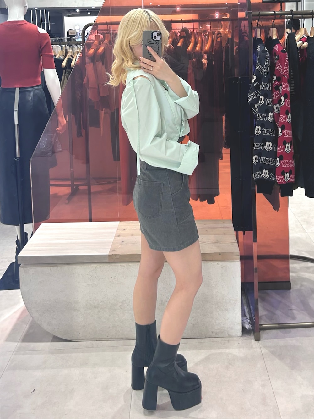 グレー系のその他パンツ、グリーン系のシャツ/ブラウス、ブラック系のブーツを着用したレディースの春コーディネートの2枚目の写真