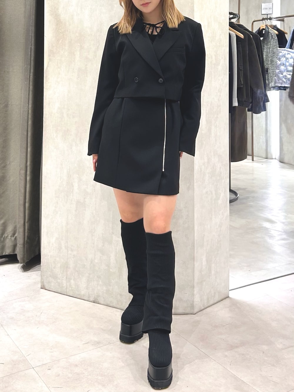 ブラック系のワンピース、ブラック系のブーツ、ブラック系のTシャツ/カットソーを着用したレディースの春コーディネートの5枚目の写真