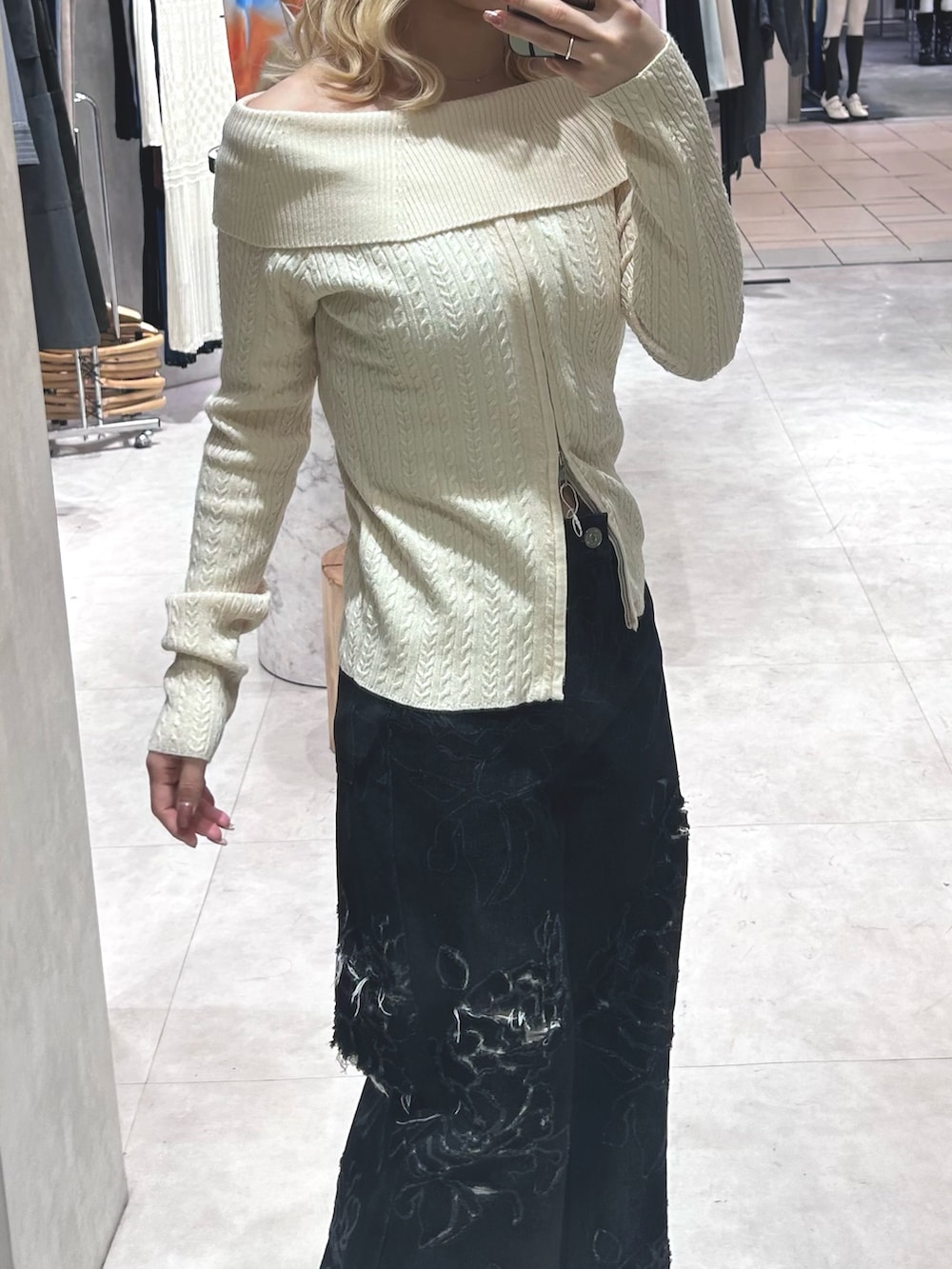 ホワイト系のニット/セーター、ブラック系のデニムパンツ、ブラック系のパンプスを着用したレディースの春コーディネートの4枚目の写真