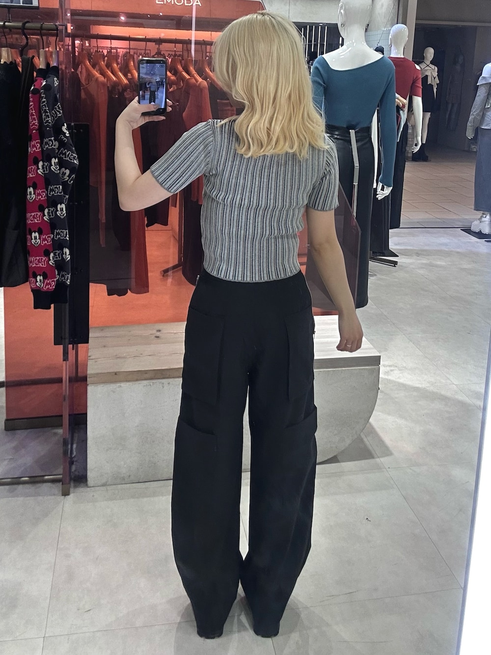 ブラック系のカーゴパンツ、ブラック系のブーツ、グレー系のニット/セーターを着用したレディースの春コーディネートの3枚目の写真