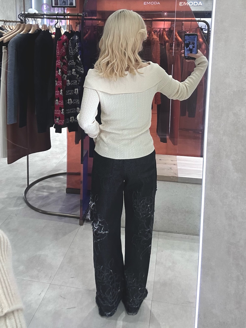 ホワイト系のニット/セーター、ブラック系のデニムパンツ、ブラック系のパンプスを着用したレディースの春コーディネートの3枚目の写真