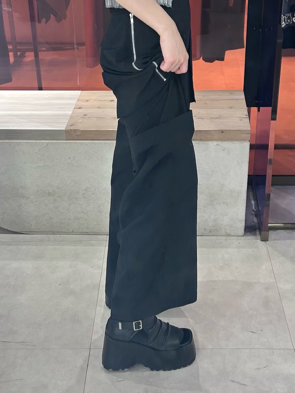 ブラック系のカーゴパンツ、ブラック系のブーツ、グレー系のニット/セーターを着用したレディースの春コーディネートの4枚目の写真