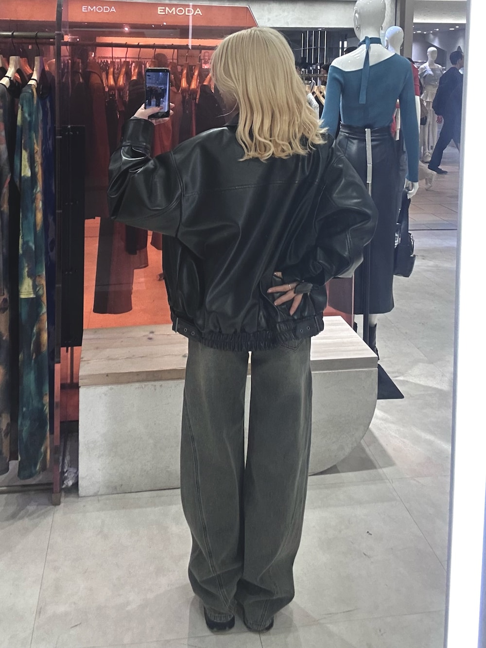 グレー系のデニムパンツ、ブラック系のブルゾン、グレー系のニット/セーターを着用したレディースの春コーディネートの3枚目の写真