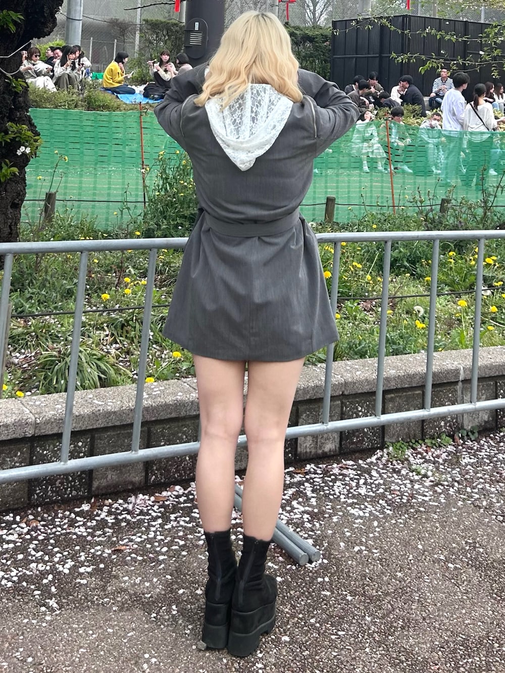 グレー系のテーラードジャケット、ホワイト系のパーカー、ブラック系のブーツを着用したレディースの春コーディネートの3枚目の写真