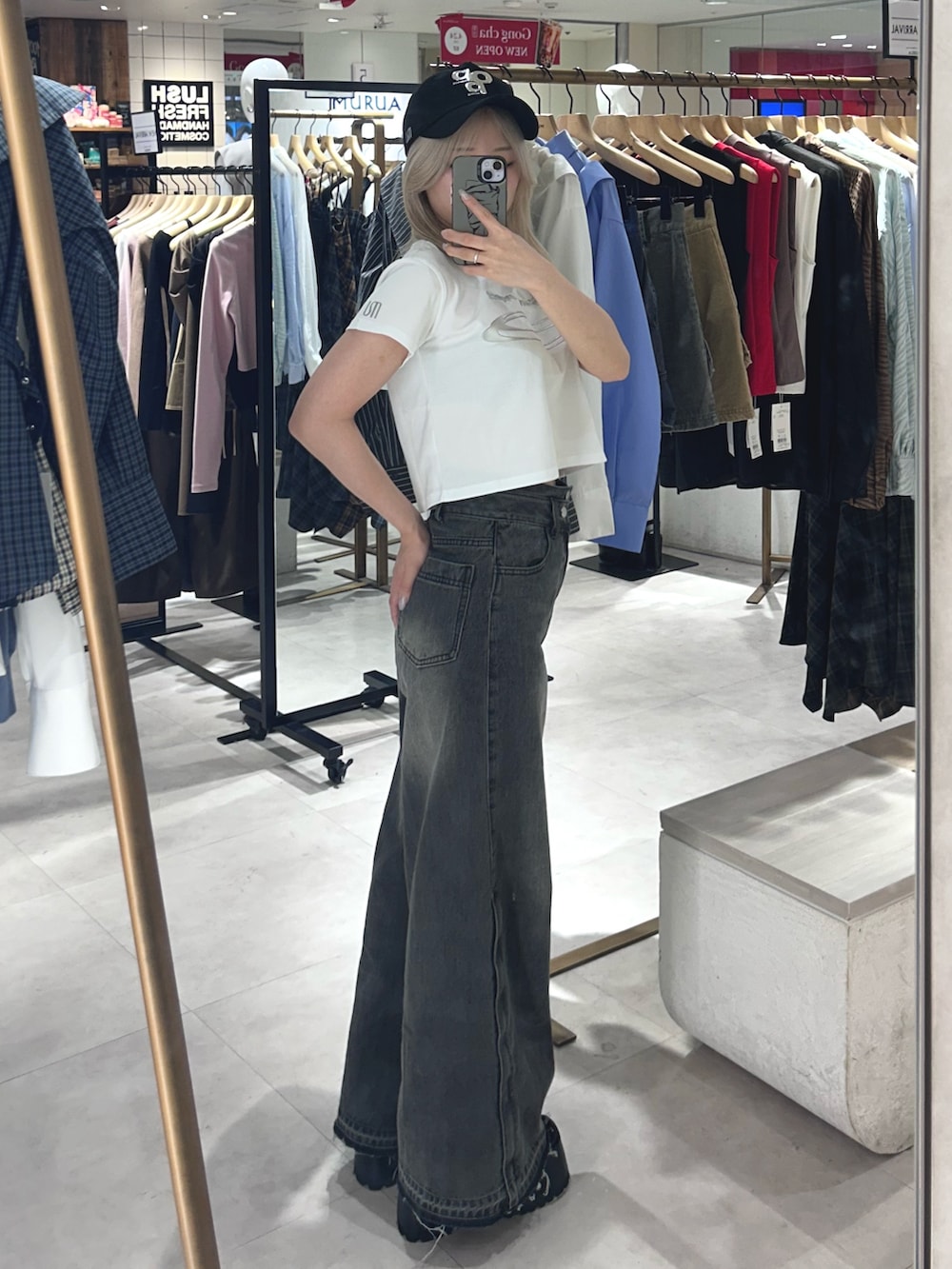 ブラック系のデニムパンツ、ブラック系のブーツ、ホワイト系のTシャツ/カットソーを着用したレディースの春コーディネートの2枚目の写真