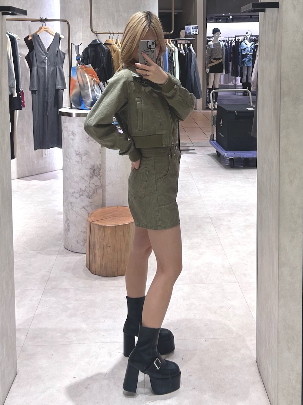 ブラック系のブーツ、グリーン系のブルゾン、ブラウン系のTシャツ/カットソーを着用したレディースの春コーディネートの2枚目の写真