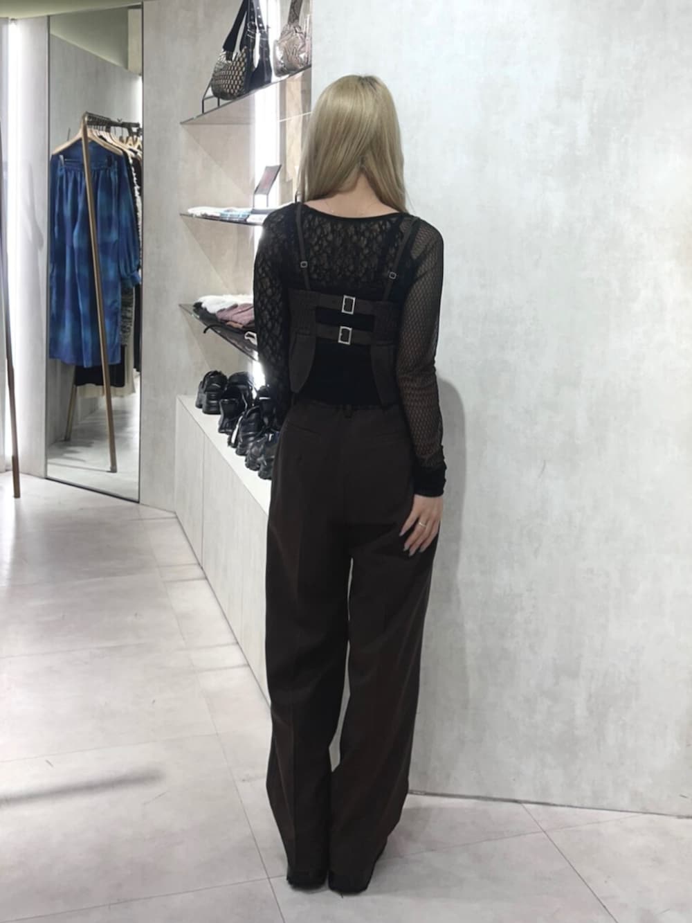 ブラック系のブーツ、ブラウン系のスラックス、ブラック系のTシャツ/カットソーを着用したレディースの秋コーディネートの3枚目の写真