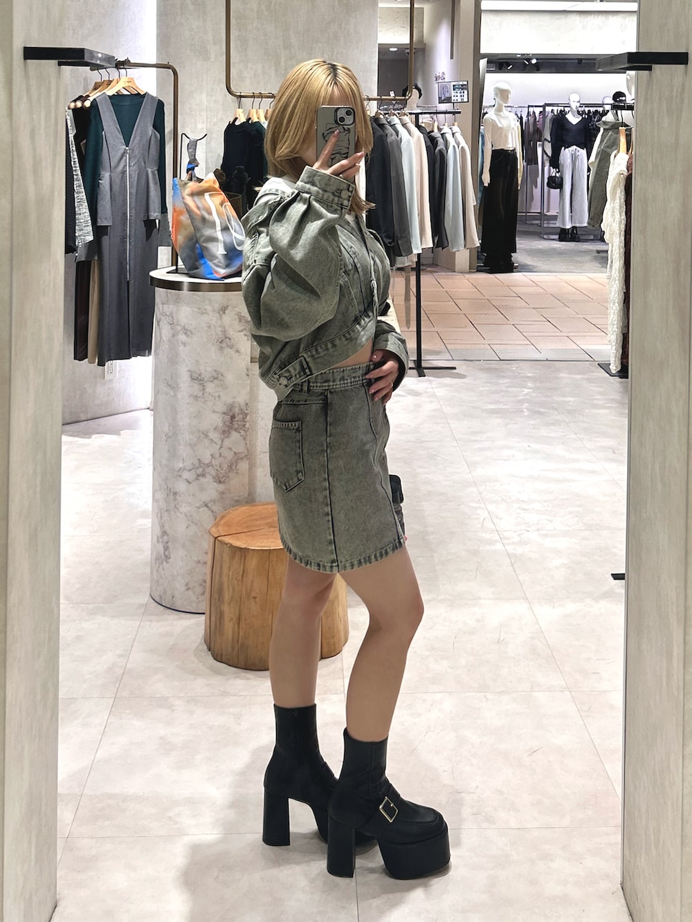 ブラック系のブーツ、ホワイト系のTシャツ/カットソー、グリーン系のデニムジャケットを着用したレディースの冬コーディネートの2枚目の写真