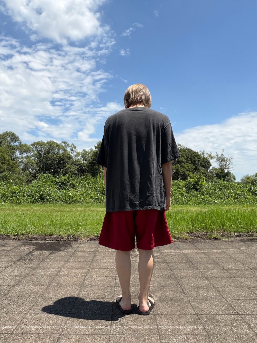 ブラック系のTシャツ/カットソー、レッド系のパンツを着用したメンズの夏コーディネートの3枚目の写真