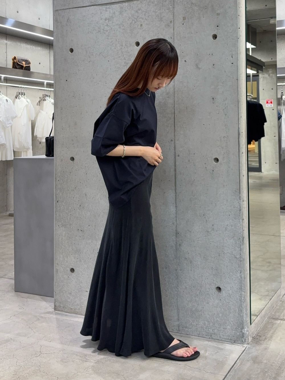 ブルー系のTシャツ/カットソー、ブラック系のスカート、ブラック系のサンダルを着用したレディースの夏コーディネートの5枚目の写真