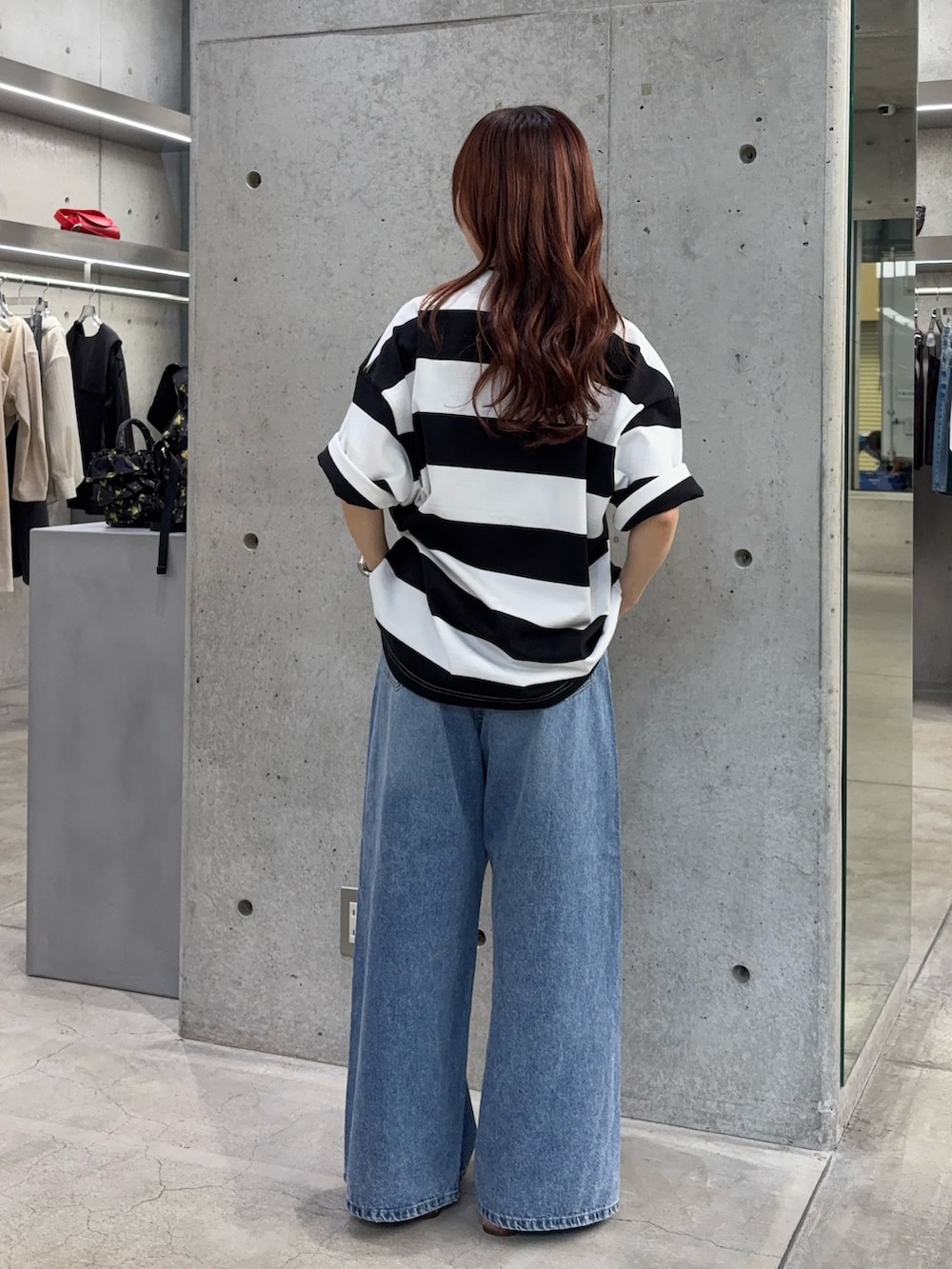 ブルー系のデニムパンツ、ベージュ系のバレエシューズ、ホワイト系のTシャツ/カットソーを着用したレディースの夏コーディネートの3枚目の写真