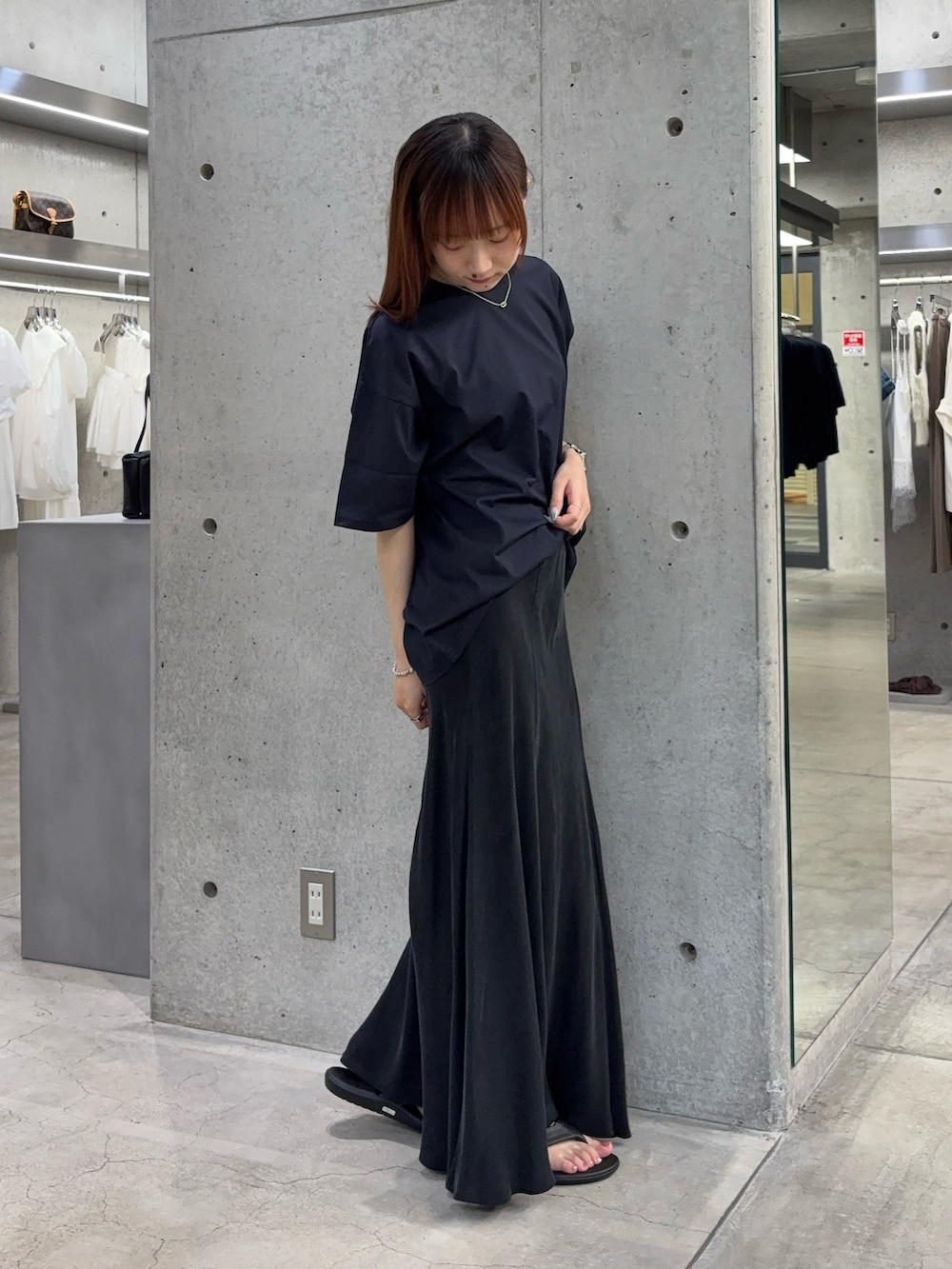 ブルー系のTシャツ/カットソー、ブラック系のスカート、ブラック系のサンダルを着用したレディースの夏コーディネートの6枚目の写真