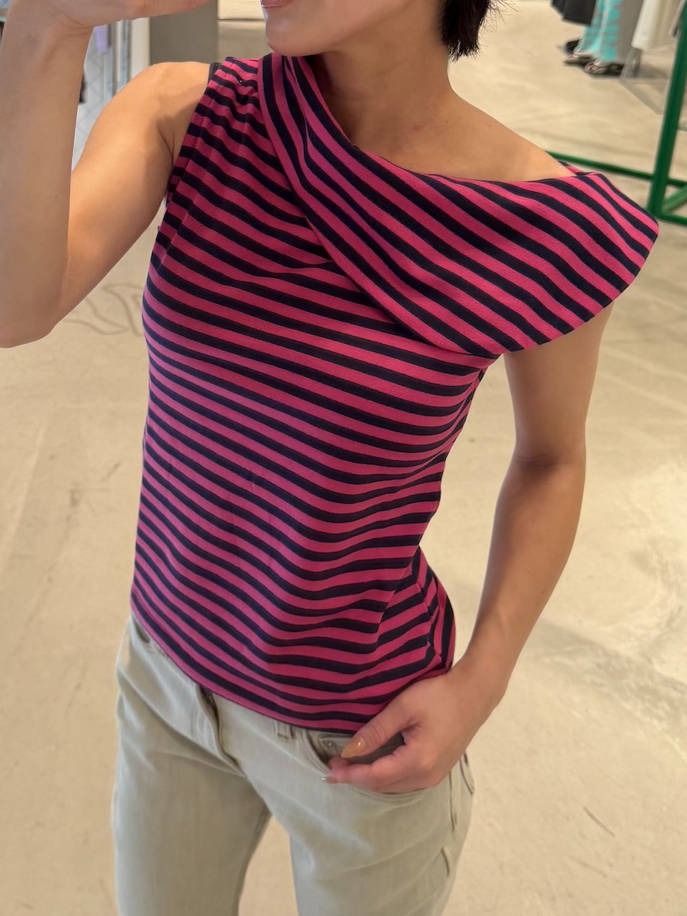 ベージュ系のデニムパンツ、グリーン系のTシャツ/カットソー、ブルー系のキャップを着用したレディースの秋コーディネートの2枚目の写真