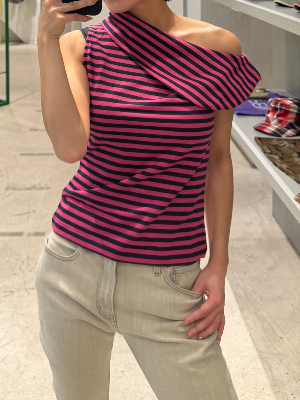 ベージュ系のデニムパンツ、グリーン系のTシャツ/カットソー、ブルー系のキャップを着用したレディースの秋コーディネートの3枚目の写真