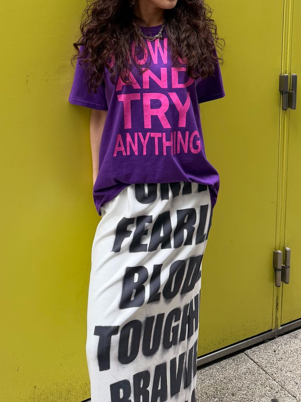 パープル系のTシャツ/カットソー、ホワイト系のスカート、グレー系のその他小物を着用したレディースの春コーディネートの3枚目の写真