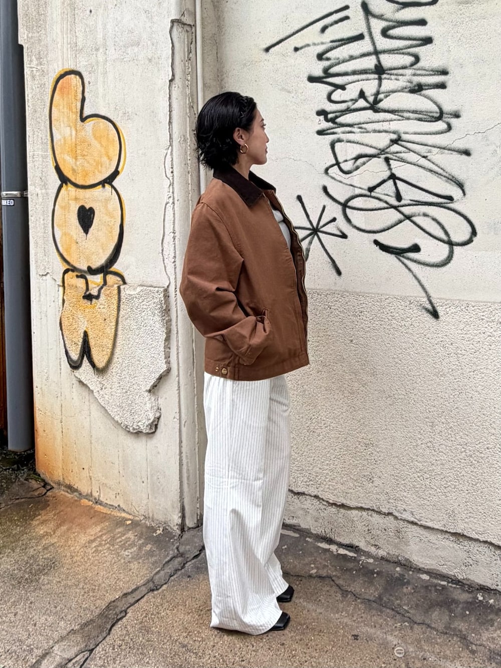 ブラウン系のその他アウター、ホワイト系のスラックス、グレー系のTシャツ/カットソーを着用したレディースの秋コーディネートの2枚目の写真
