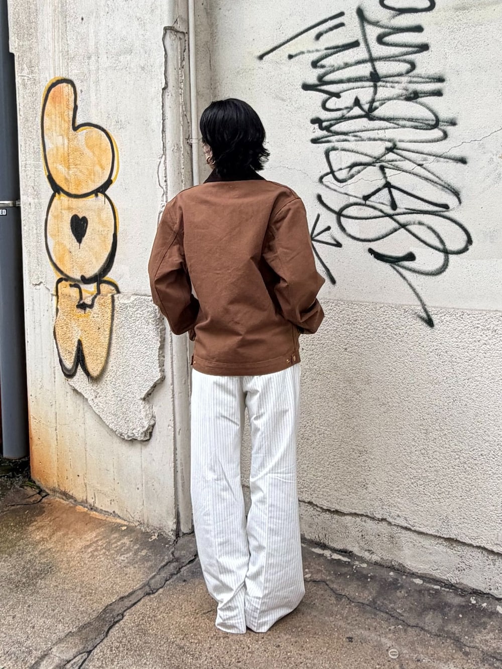 ブラウン系のその他アウター、ホワイト系のスラックス、グレー系のTシャツ/カットソーを着用したレディースの秋コーディネートの3枚目の写真