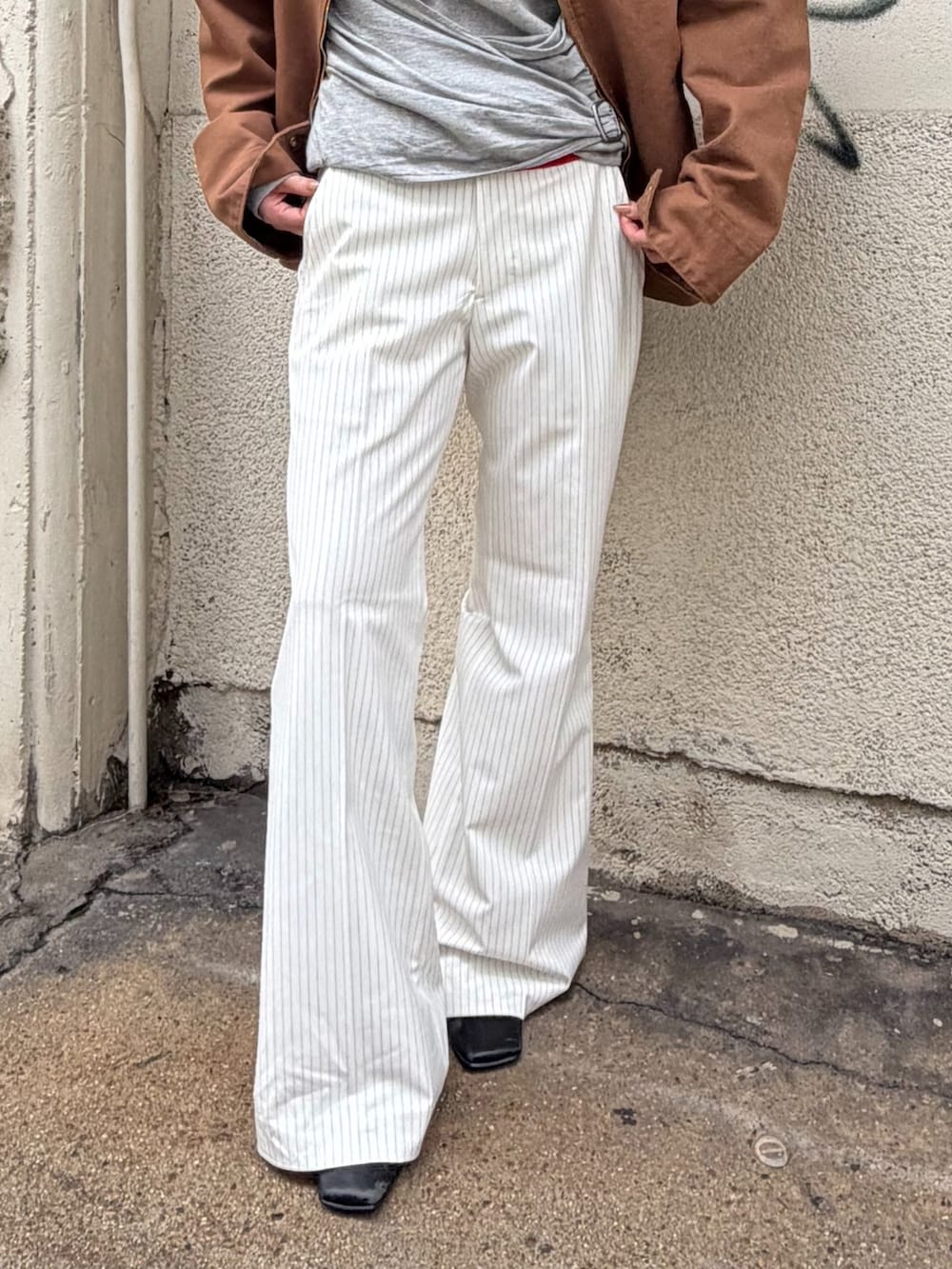 ブラウン系のその他アウター、ホワイト系のスラックス、グレー系のTシャツ/カットソーを着用したレディースの秋コーディネートの7枚目の写真