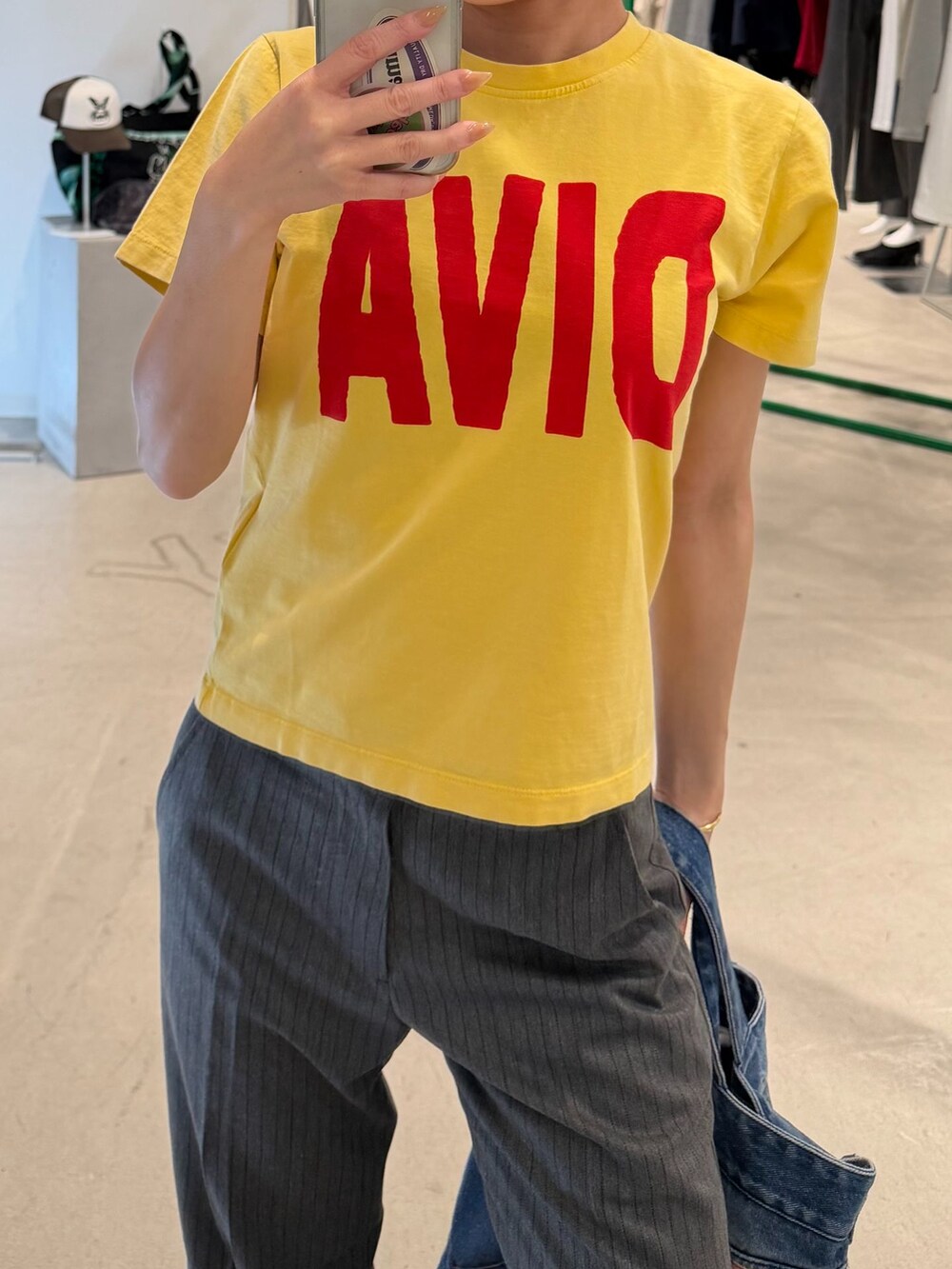 グレー系のスラックス、イエロー系のTシャツ/カットソー、ブルー系のトートバッグを着用したレディースの秋コーディネートの3枚目の写真