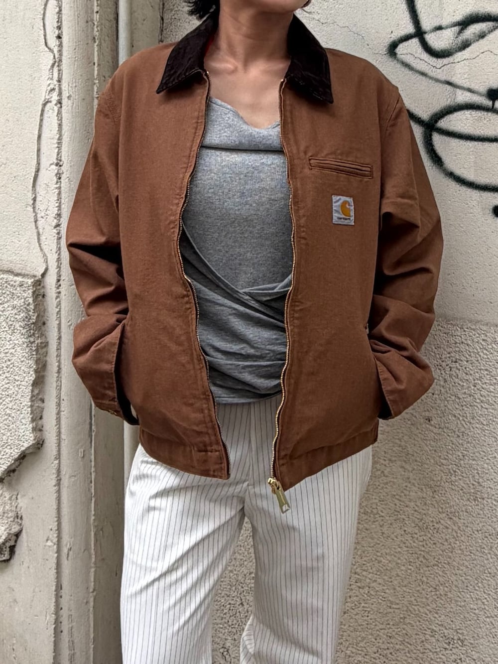 ブラウン系のその他アウター、ホワイト系のスラックス、グレー系のTシャツ/カットソーを着用したレディースの秋コーディネートの4枚目の写真
