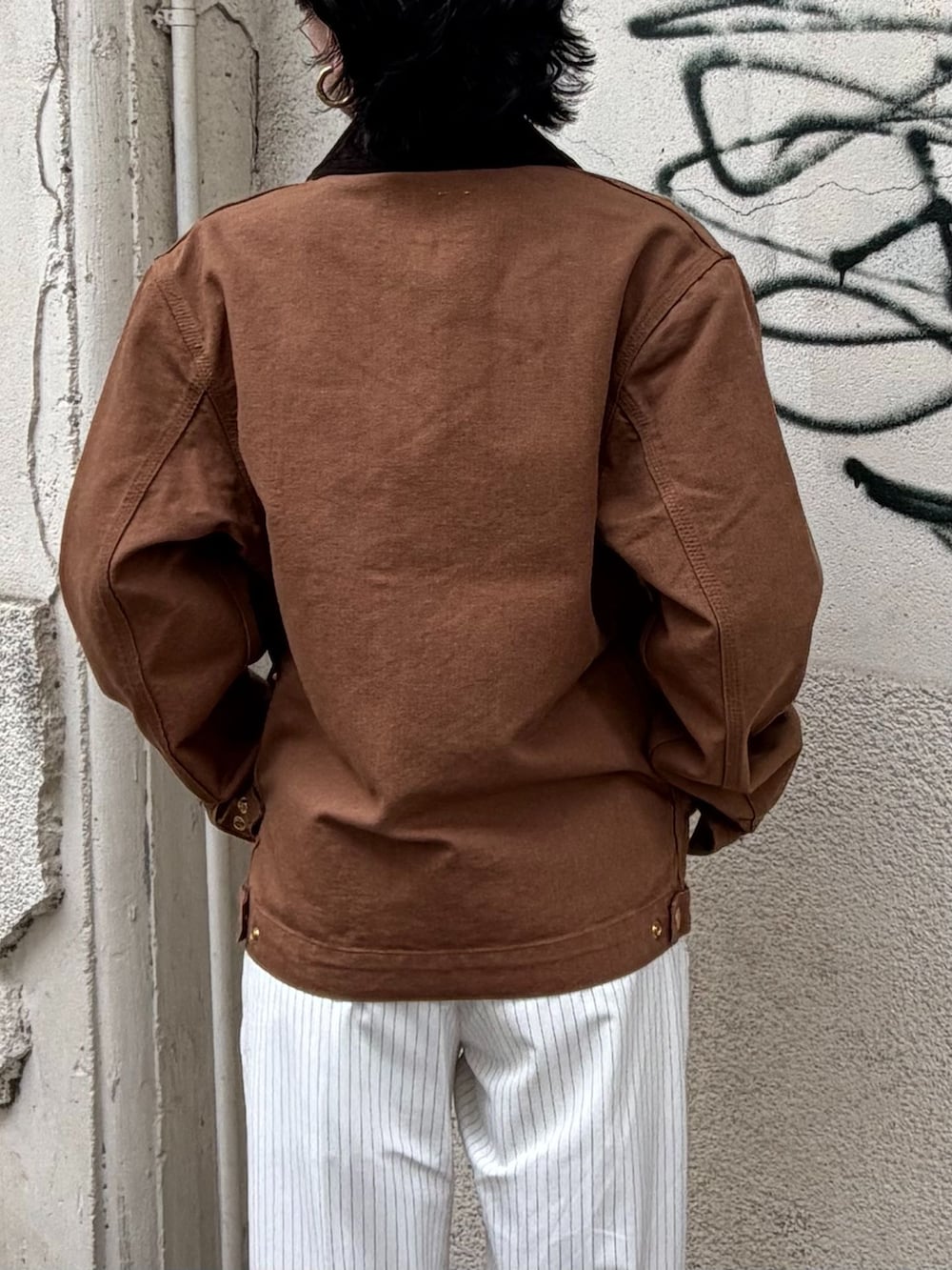ブラウン系のその他アウター、ホワイト系のスラックス、グレー系のTシャツ/カットソーを着用したレディースの秋コーディネートの6枚目の写真