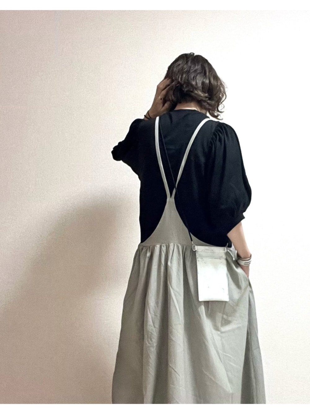 ブラック系のTシャツ/カットソー、グレー系のジャンパースカートを着用したレディースの夏コーディネートの2枚目の写真