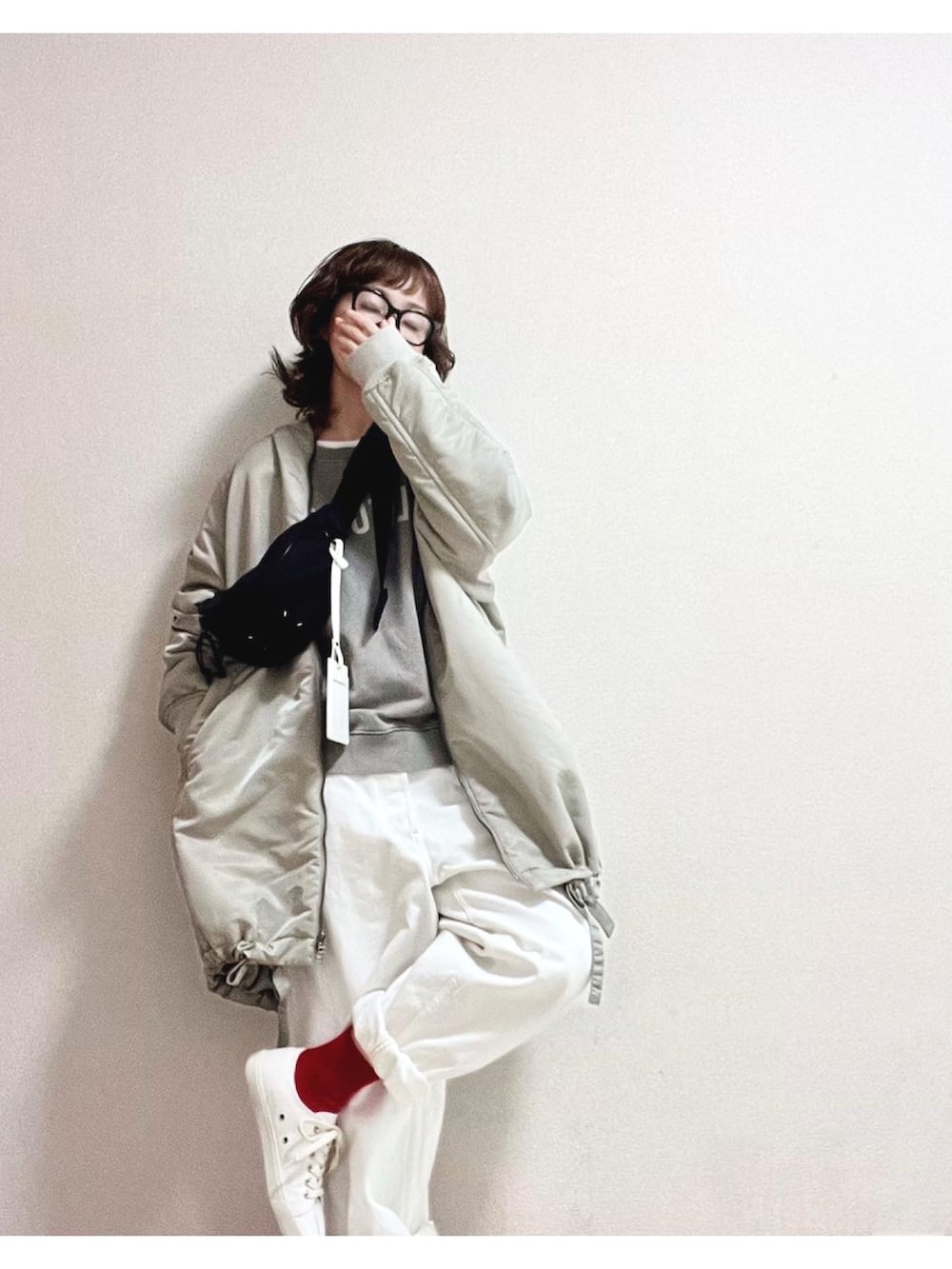 ブラック系のその他トップス、ブラック系のボディバッグ/ウエストポーチ、グレー系のナイロンジャケットを着用したレディースの冬コーディネートの2枚目の写真