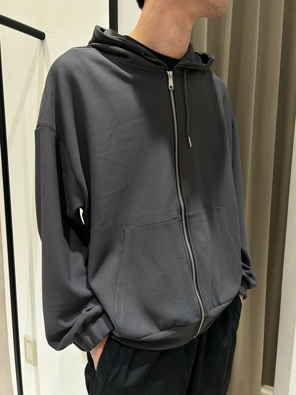 グレー系のパーカー、ブラック系のカーゴパンツを着用したメンズの秋コーディネートの3枚目の写真