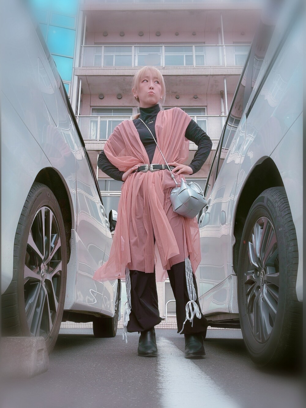 ピンク系のベスト、ブラック系のブーツ、ブラック系のトップスを着用したレディースの春コーディネートの2枚目の写真