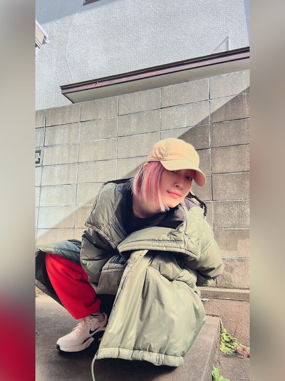 グリーン系のダウンジャケット/コート、ブラウン系のスウェットパンツ、ブラック系のスウェットを着用したレディースの冬コーディネートの3枚目の写真