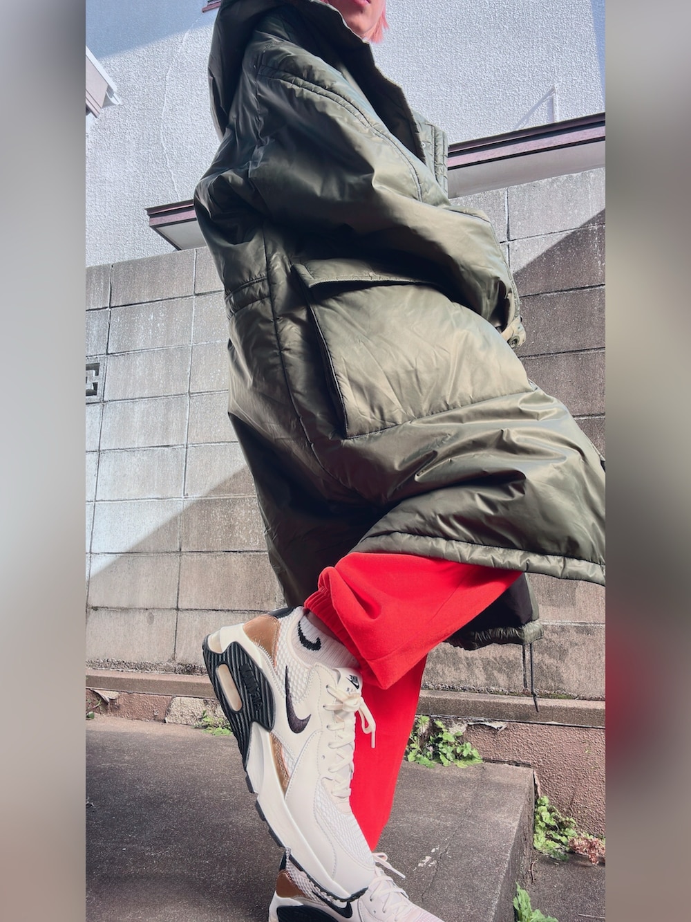 グリーン系のダウンジャケット/コート、ブラウン系のスウェットパンツ、ブラック系のスウェットを着用したレディースの冬コーディネートの2枚目の写真