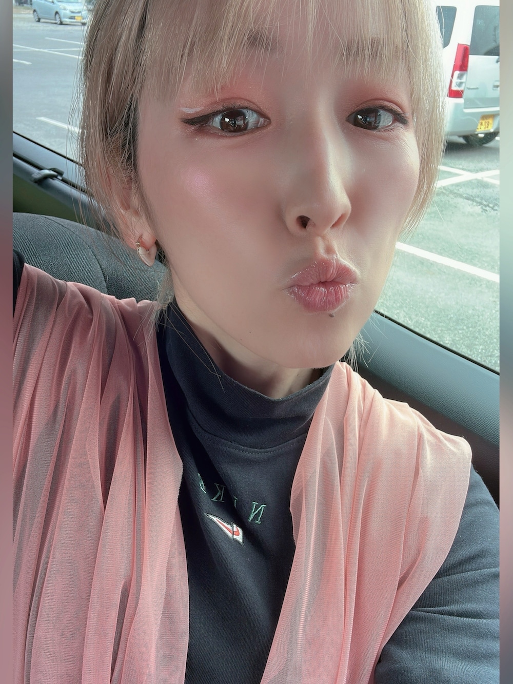 ピンク系のベスト、ブラック系のブーツ、ブラック系のトップスを着用したレディースの春コーディネートの3枚目の写真