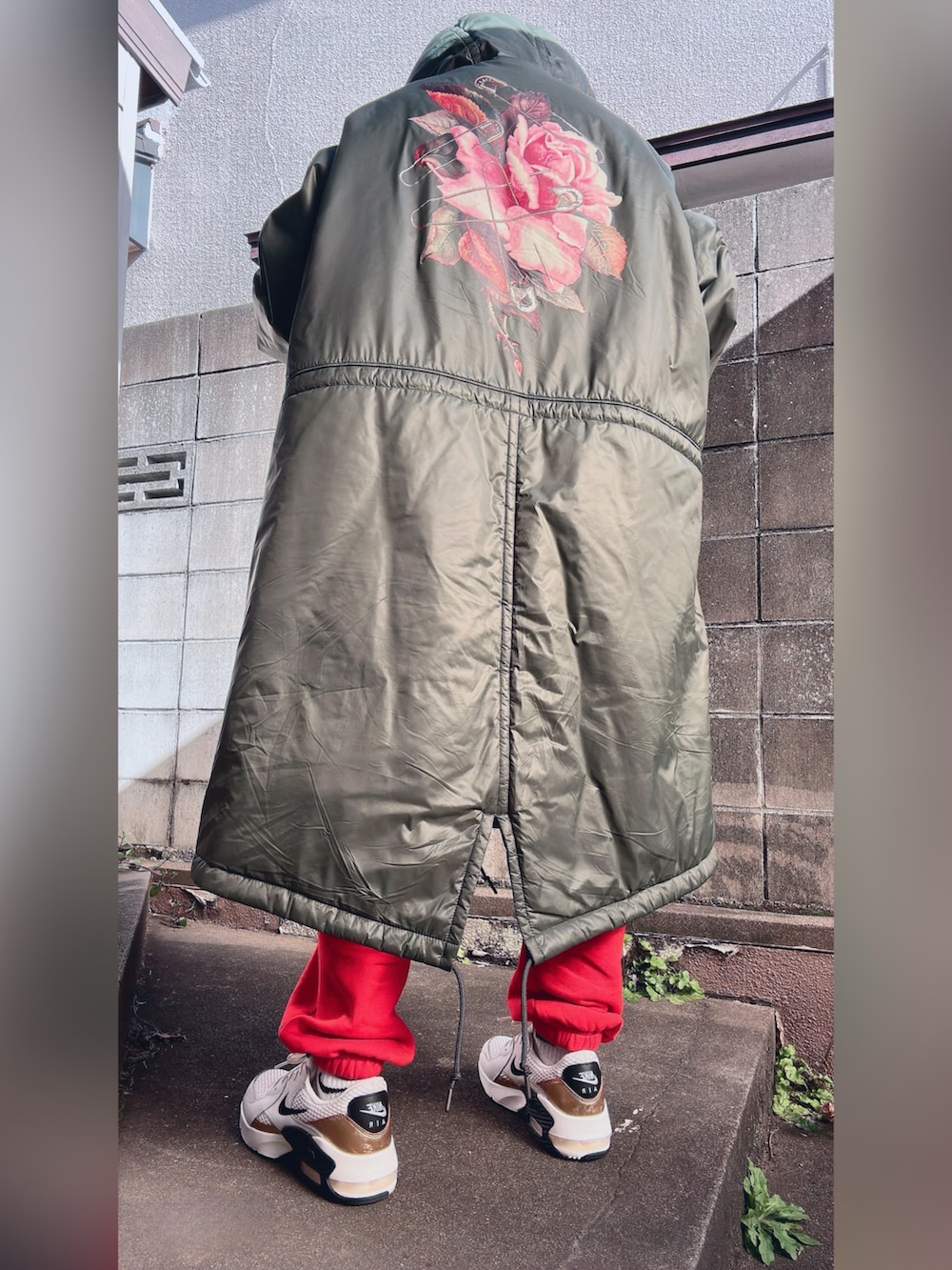 グリーン系のダウンジャケット/コート、ブラウン系のスウェットパンツ、ブラック系のスウェットを着用したレディースの冬コーディネートの5枚目の写真