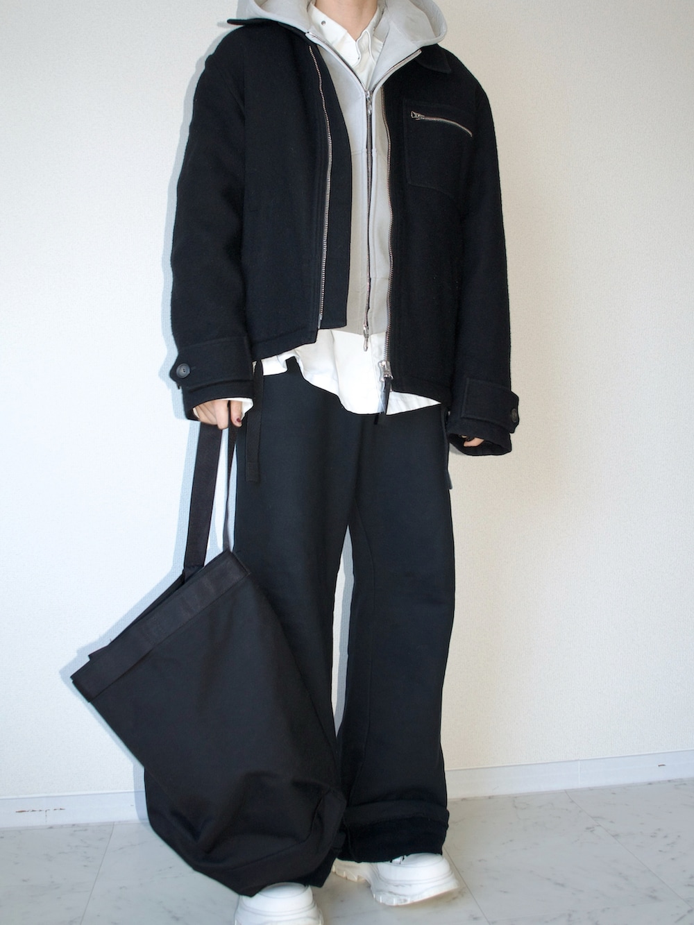 ブラック系のジャケット/アウター、グレー系のパーカー、ブラック系のその他パンツを着用したメンズの春コーディネートの2枚目の写真