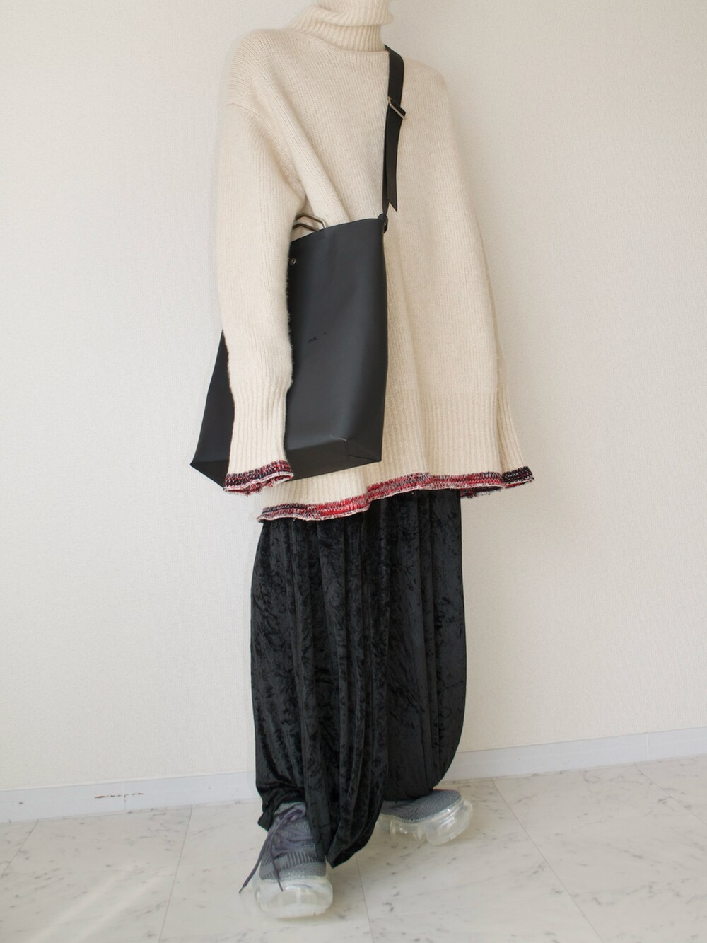 ベージュ系のニット/セーター、ブラック系のパンツ、ブラック系のバッグを着用したメンズの春コーディネートの2枚目の写真