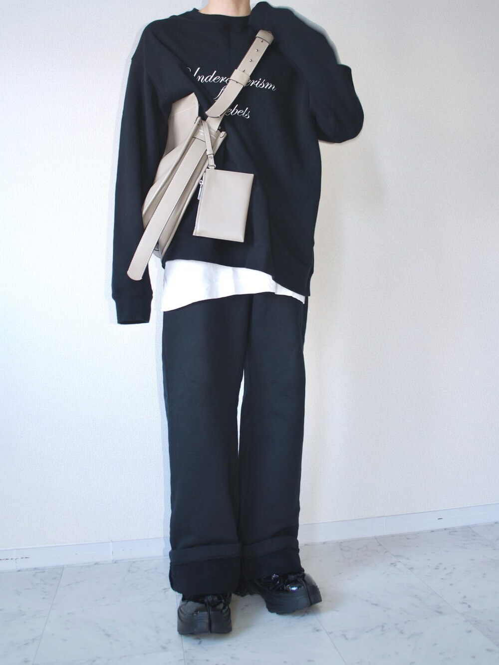 ブラック系のスウェット、ブラック系のスウェットパンツ、ブラック系のスニーカーを着用したメンズの春コーディネートの2枚目の写真