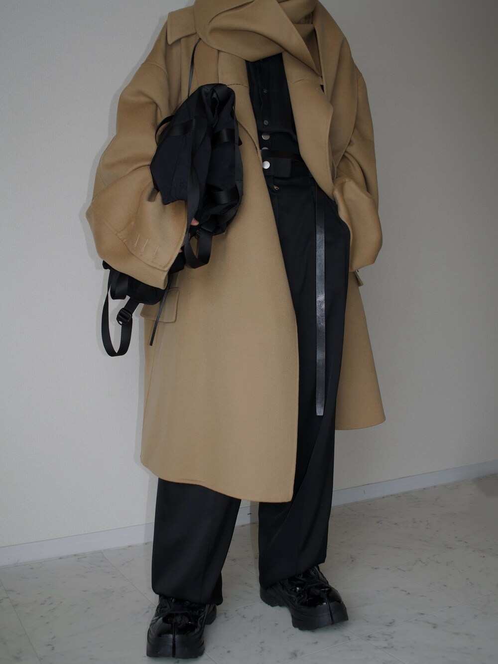 ベージュ系のジャケット/アウター、ブラック系のスラックス、ブラック系のバックパック/リュックを着用したメンズの冬コーディネートの2枚目の写真