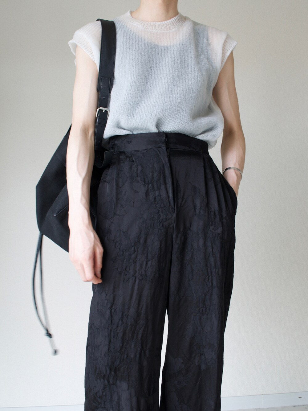 ホワイト系のTシャツ/カットソー、ブラック系のスラックス、ブラック系のバッグを着用したメンズの夏コーディネートの2枚目の写真
