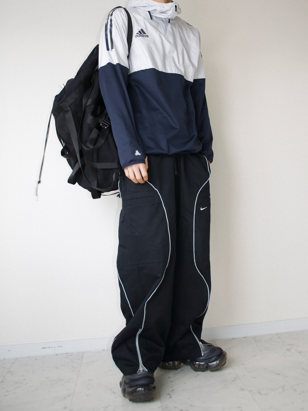 グレー系のトップス、ブラック系のその他パンツ、ブラック系のスニーカーを着用したメンズの春コーディネートの2枚目の写真