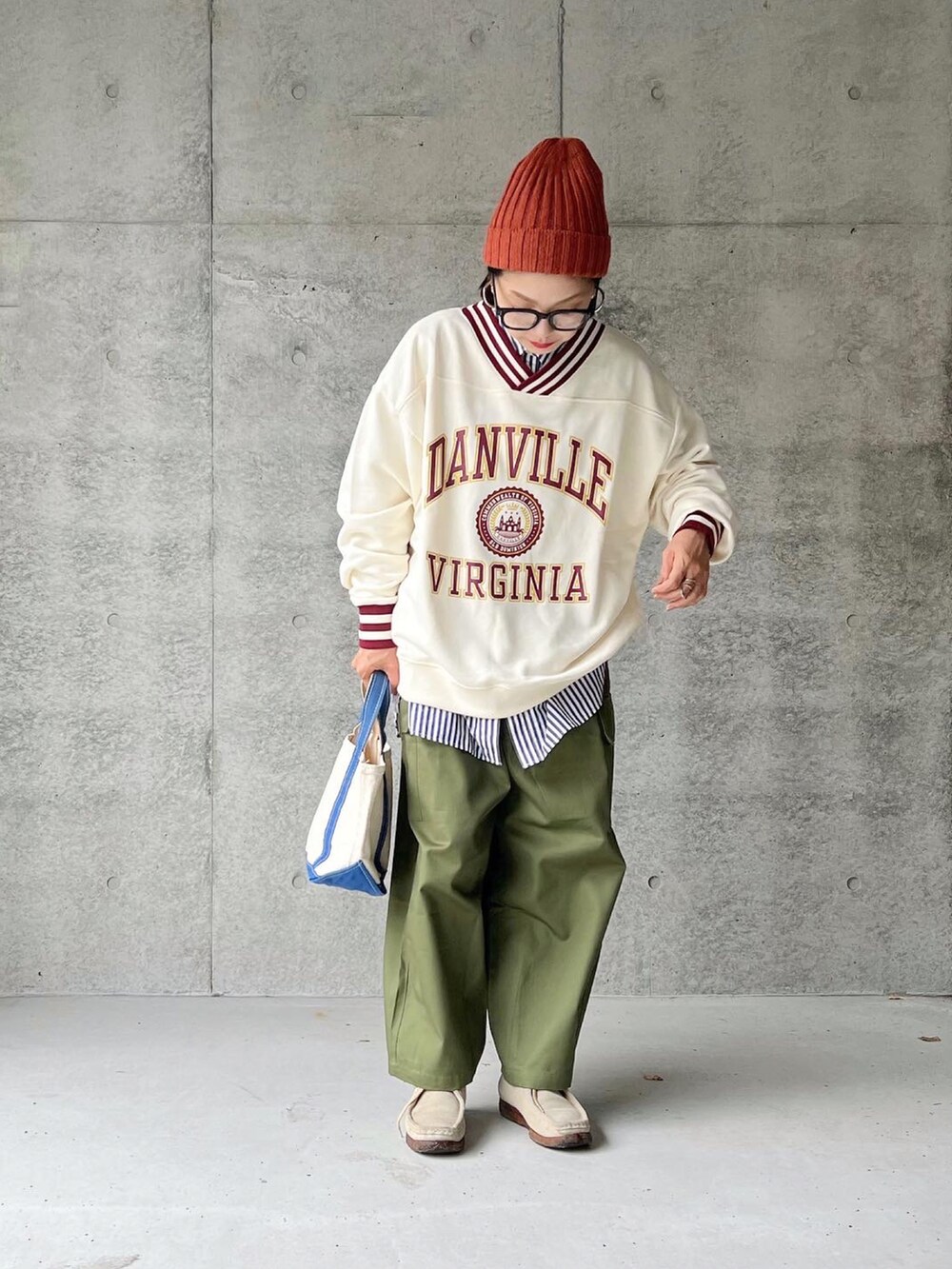 ホワイト系のスウェット、グリーン系のカーゴパンツ、ブルー系のトートバッグを着用したレディースの秋コーディネートの2枚目の写真